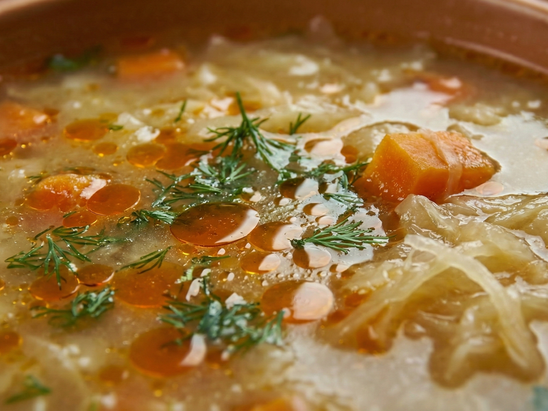 Close-up of a bowl of soup with carrots and herbs | Cook & Keeper - kapusniak